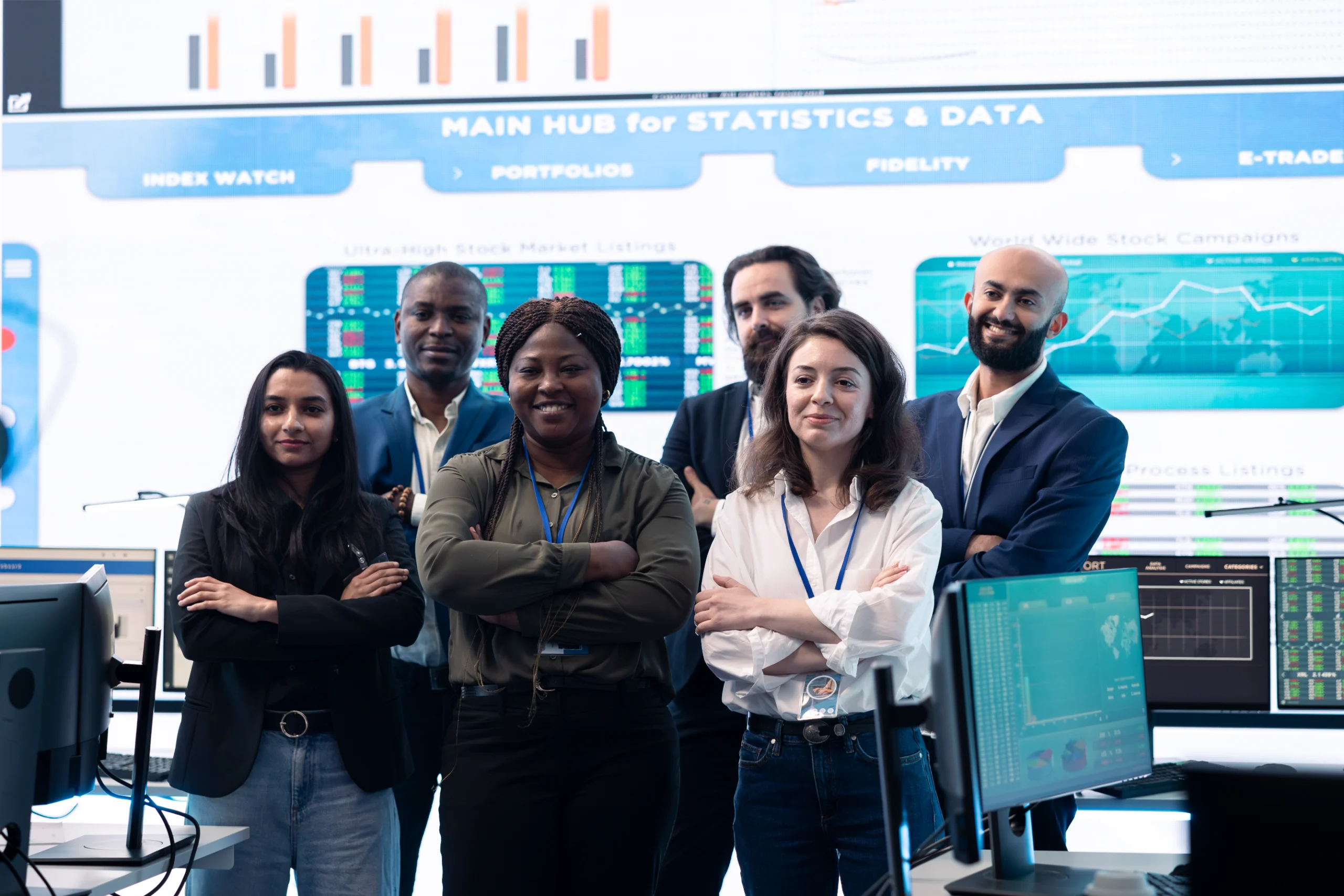 confident-smiling-enterprise-team-uniting-their-fo-2025-02-20-01-59-34-utc Multiracial team of smiling men and women stnading in front of wall of statistics and other data displays